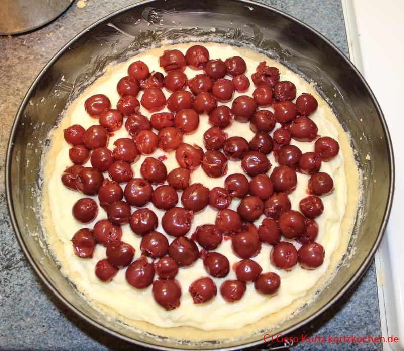 Streuselkuchen mit Pudding-Creme von Dr. Oetker- Kirschen auf dem Kuchen in der Springform verteilt