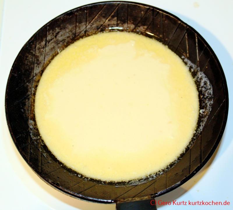 Rezept für schnellen Eierkuchen - frischer Eierkuchenteig in einer Pfanne aus Gusseisen