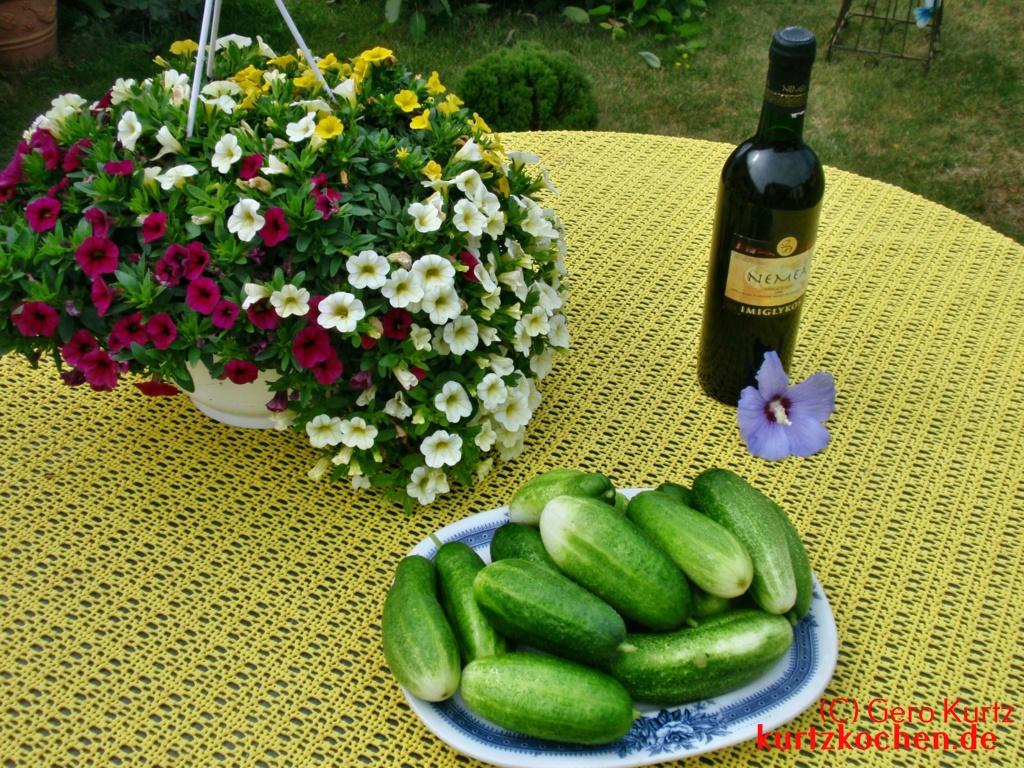 Teller mit Gurken auf einem Tisch mit Blumen und Wein